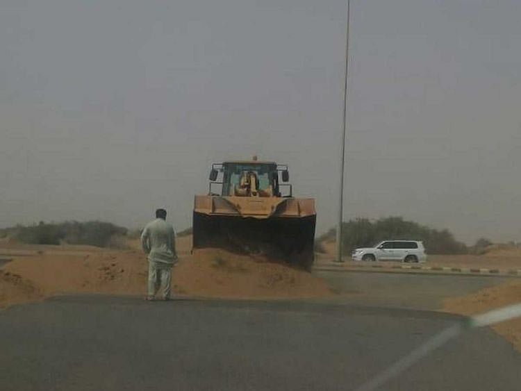 A bulldozer reopens a blocked road in the Saudi town of Saeeda Sawalha.