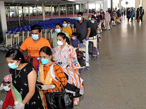 Indian citizens queue at Kuwait International Airport before boarding a repatriation flight to India, in Kuwait City, on May 9, 2020. 