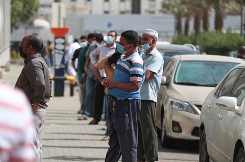 Mask-clad men wait outside a shop in Mecca. The ministry said that the Kingdom will return to the normalcy based on the health authorities’ recommendation.