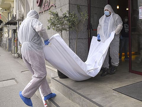 Forensic workers carry a body from a hotel downtown Bucharest, Romania, Friday. Gholamreza Mansouri, a former judge from Iran sought by his country to face corruption charges has died in unusual circumstances, Romanian media reported.  
