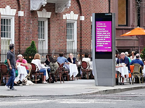 A restaurant on Madison Avenue serves drinks to customers seated at sidewalk tables as the city moves into phase two re-opening from the coronavirus pandemic on June 20, 2020 in New York City. 