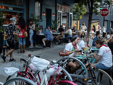 Customers dine outside Dudley's, Monday, June 22, 2020, in New York. New York City ventured into a crucial stage of reopening as stores let people in Monday, offices brought workers back, restaurants seated customers outdoors and residents both welcomed and worried about rebounding from the nation's deadliest coronavirus outbreak.