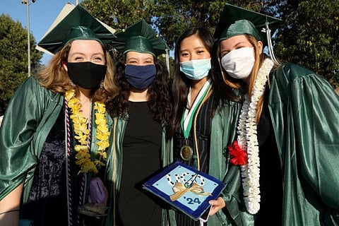 New West Charter School graduates smile beneath their masks to prevent coronavirus after their drive-by graduation in Stoner Park in Los Angeles on June 10, 2020. 