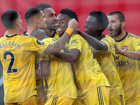 Arsenal's English midfielder Joe Willock (C) is mobbed by teammates after scoring the second goal against Southampton.