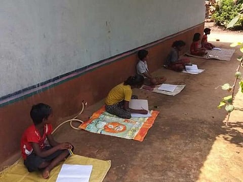 Children in Jharkhand sit down in the shade to attend daily classes.