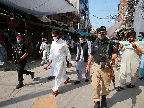 Pakistani officials visit a market to check the standard operating procedures imposed by the government to control the spread of the new coronavirus, in Peshawar, Pakistan, Friday, June 26, 2020. 