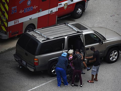A nurse helps people put a woman in a wheelchair at the Houston Methodist Hospital emergency room amid a coronavirus disease (COVID-19) outbreak in Houston, Texas, U.S., June 28, 2020.