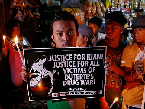 File Photo | Protesters and residents hold lighted candles and placards at the wake of Kian delos Santos, a 17-year-old high school student, who was among the people shot dead in an escalation of President Rodrigo Duterte's war on drugs in Caloocan city, Metro Manila, Philippines