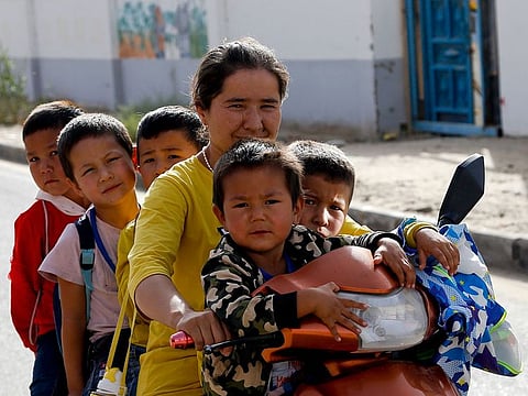 An Uighur woman and children sit on a motor-tricycle after school at the Unity New Village in Hotan, in western China's Xinjiang region. Birth rates in the mostly Uighur regions of Hotan and Kashgar have plunged by more than 60% since 2015, government statistics show.