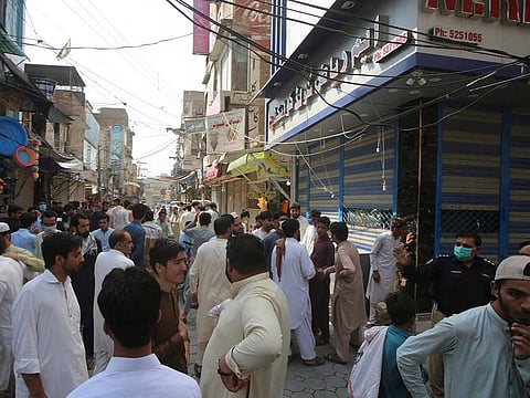 Shopkeepers stand outside their shops that were closed by authorities to help to control the spread of the coronavirus, in Peshawar, Pakistan, Monday, June 29, 2020.