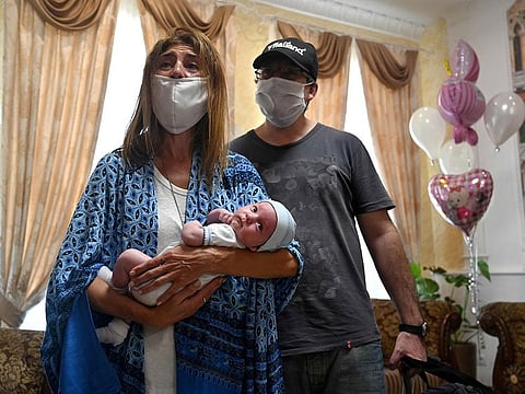 Argentinian Andrea Viez holds her baby as she and her husband collect their son born to a surrogate mother, in the Hotel Venice in Kiev, on June 10.