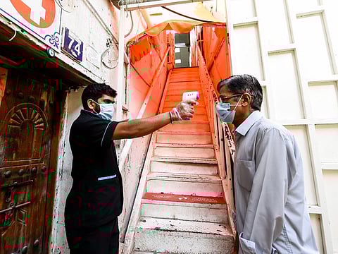 A visitor's temperature being checked at the entrance to Bur Dubai temple on Wednesday after it reopened
