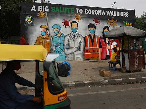 An autorickshaw drives past a graffiti thanking frontline workers in the fight against the coronavirus, in New Delhi, India