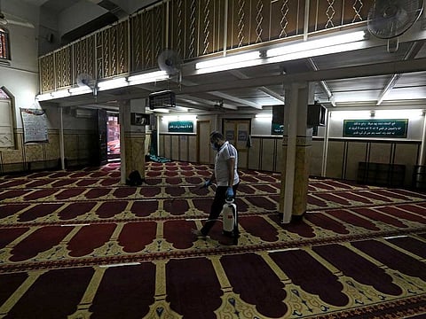 A volunteer wearing a face mask sprays disinfectant inside a mosque as it is prepared for prayer after being reopened, following the outbreak of the coronavirus disease (COVID-19), in Cairo, Egypt, June 26, 2020. 