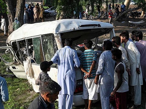 Residents gather around the wreckage of a van alongside a railway track following the accident between a train and the van transporting Sikh pilgrims in Farooqabad area in Sheikhupura district of the Pakistan's Punjab province on July 3, 2020. At least 20 Sikh pilgrims were killed on July 3 when a train smashed into a van in the east of Pakistan, officials said.