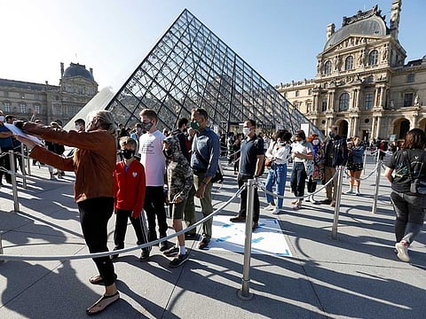Visitors queue in front of the Louvre Pyramid designed by Chinese-born US architect Ieoh Ming Pei in Paris as the museum reopens its doors to the public after almost 4-month closure due to the coronavirus disease (COVID-19) outbreak in France, July 6, 2020.