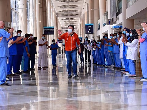 Hiroaki Fujita from Japan, the last patient at the temporary COVID-19 hospital built in downtown Dubai in the United Arabic Emirates, greets nurses and doctors as he leaves the facility, on July 7, 2020. (Photo by GIUSEPPE CACACE / AFP)