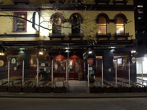 A patron sits alone outside a pub in Melbourne, Australia, on Wednesday, July 8, 2020. The six-week stay-at-home order that will come into force at midnight across the Victoria state capital is set to devastate the city’s restaurants, cafes, beauty spas and small retailers, which were just taking their first tentative steps back to business-as-usual.