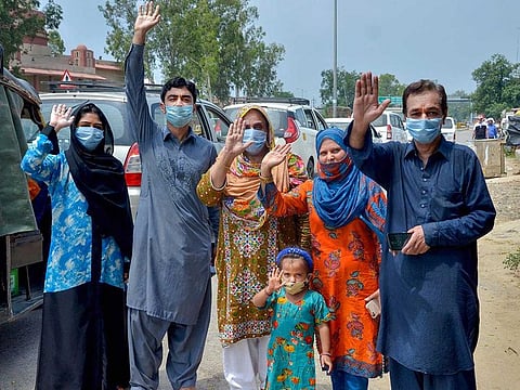 Pakistani nationals who were stranded in India due to the closure of borders following coronavirus pandemic, wave before crossing the India-Pakistan Wagah Border Post, during Unlock 2.0, in Attari, Thursday, July 9, 2020. 