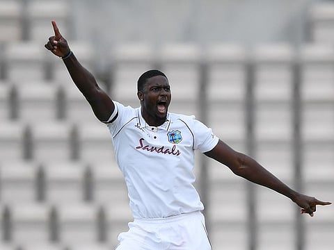 West Indies' Jason Holder celebrates taking the wicket of England's Ben Stokes in the first Test
