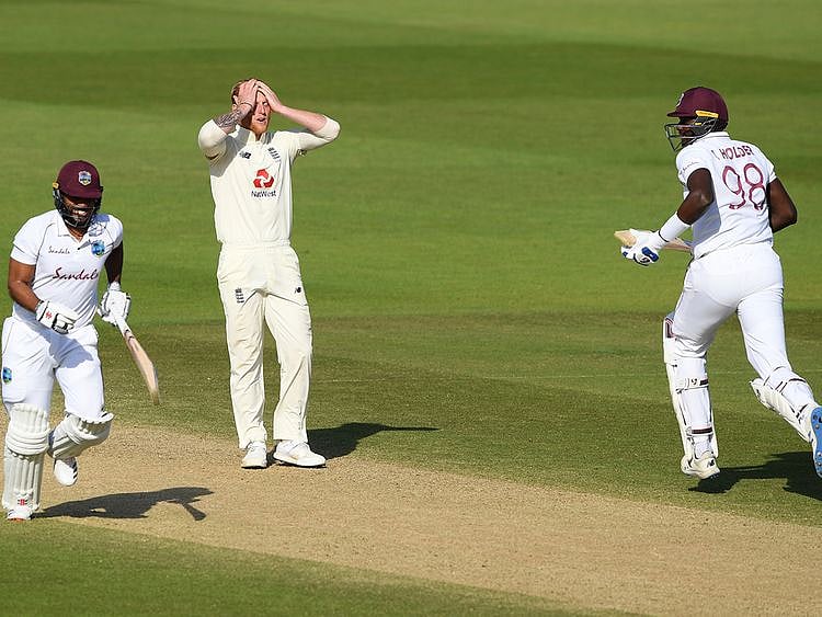 England captain Ben Stokes reacts as West Indies captain Jason Holder, right, and John Campbell, left, take a run 