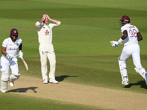 England captain Ben Stokes reacts as West Indies captain Jason Holder, right, and John Campbell, left, take a run 