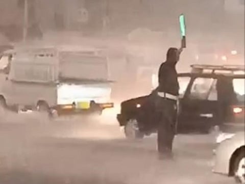 Traffic police officer, Imran Asif, on duty amidst heavy rain in Rawalpindi