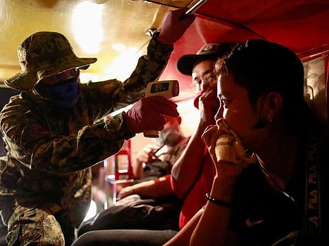 File photo: A police officer checks a jeepney passenger's body temperature at a checkpoint placed amidst the lockdown of the country's capital to contain the spread of coronavirus in Metro Manila, Philippines.