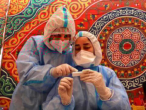 Doctors from the Palestinian Ministry of Health take blood samples from a person suspected of being infected with the novel coronavirus COVID-19 in Hebron in the occupied West Bank on July 15, 2020. 
