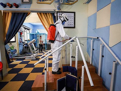 A member of the Syrian Civil Defence, also known as the "White Helmets" disinfects a room at a physiotherapy centre in Syria's rebel-held northwestern city of Idlib, on July 11, 2020. A first case of coronavirus was recorded in northwest Syria on July 9, an opposition official said, reviving fears of disaster if the pandemic reached the rebel bastion's displacement camps. 