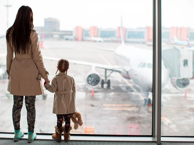 Child and mother watching plane in airport