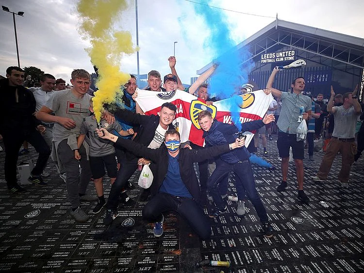 Leeds United fans celebrate outside Elland Road, Friday, July 17, 2020, on Leeds, England, after Huddersfield Town beat West Bromwich Albion to seal their promotion to the Premier League. (Nick Potts/PA via AP)