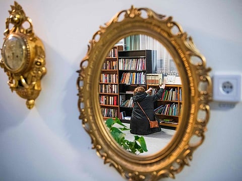 A picture taken on November 15, 2019 shows the reflection of a woman in a mirror displayed for sale at "ReTuna", a shopping centre dedicated to second-hand objects, in Eskilstuna, Sweden