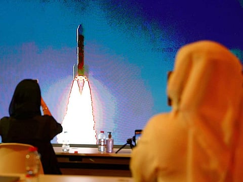 People watch a big screen displaying the launch of the Hope Probe from Tanegashima Island in Japan, at the Mohammed bin Rashid Space Centre in Dubai.