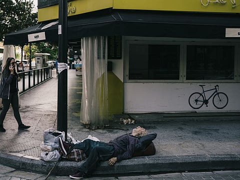 A man sleeps on a sidewalk on Hamra street, a main commercial thoroughfare in Beirut, in front of a shop that was closed because of the economic crisis