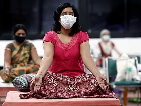 People suffering from the coronavirus disease (COVID-19) perform yoga inside a care centre for COVID-19 patients at an indoor sports complex in New Delhi, India, July 21, 2020. 