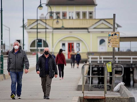 Walkers wear protective face masks at St Kilda pier in Melbourne after it became the first city in Australia to enforce mask-wearing in public as part of efforts to curb a resurgence of the coronavirus disease (COVID-19), July 23, 2020.