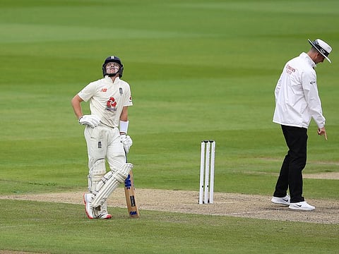 England's Ollie Pope, left, looks skywards during the first day of the third Test matchagainst West Indies at Old Trafford 