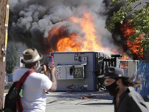 Construction buildings burn near the King County Juvenile Detention Centre, Saturday on July 25 in Seattle, shortly after protesters left the area. 