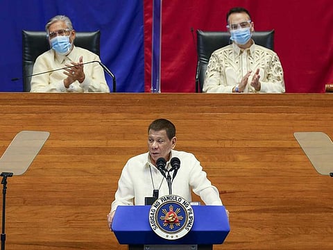 In this handout photo provided by the Malacanang Presidential Photographers Division, Philippine President Rodrigo Duterte, center, delivers his State of the Nation Address (SONA) while Senate President Vicente Sotto III, left, and House Speaker Alan Peter Cayetano applauds at the House of Representative in Metro Manila, Philippines, Monday, July 27, 2020. 