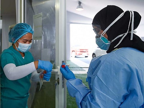 Paramedics collecting the swab samples at coronavirus drive-through screening station Sharjah Golf and Shooters Club in Sharjah