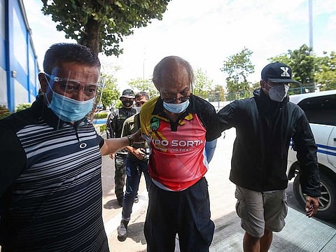 Ruben Ecleo is escorted by plainclothes police at police regional headquarters following his arrest in Manila.