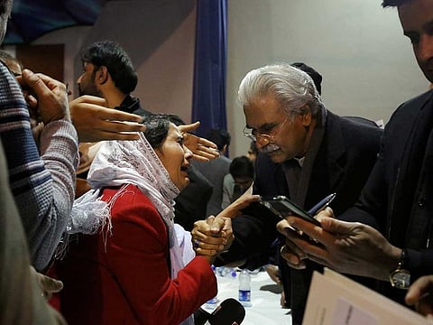 Zafar Mirza (R), Pakistan's special aide on health to Prime Minister Imran Khan, interacts with a woman in Islamabad, Pakistan February 19, 2020. 