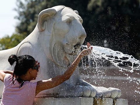 A woman refreshes herself at a fountain in downtown Rome, Italy, July 30, 2020. 