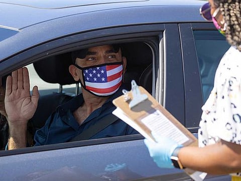 A US immigration officer administers the oath to Palestinian Omar Abdalla during a swearing-in of newly naturalised United States citizens in an empty parking lot during the outbreak of the coronavirus disease (COVID-19) in Santa Ana, California, US, on July 29, 2020.