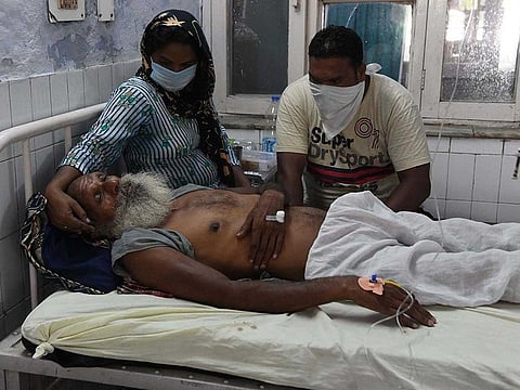 Relatives sit near patient, who is being treated at a civil hospital after allegedly drinking spurious alcohol. Photo for illustrative purpose.