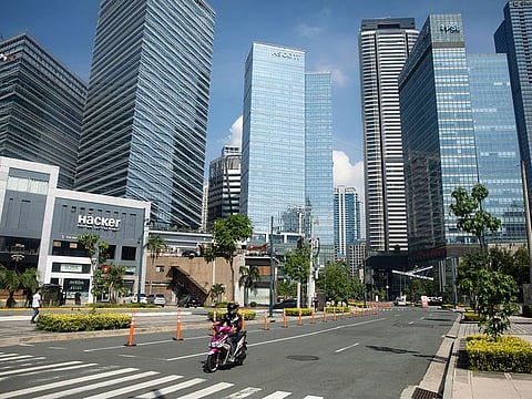 A motorcyclist travels along a deserted road in Bonifacio Global City, Metro Manila, the Philippines.