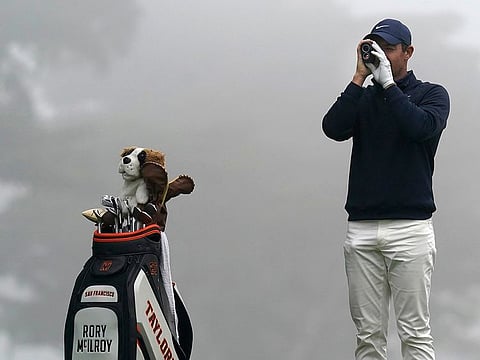 Taylor-made for glory: Rory McIlroy surveys a course as the branded bag rests near him.
