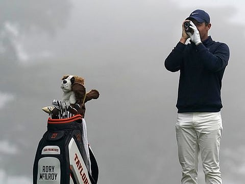 Taylor-made for glory: Rory McIlroy surveys a course as the branded bag rests near him.