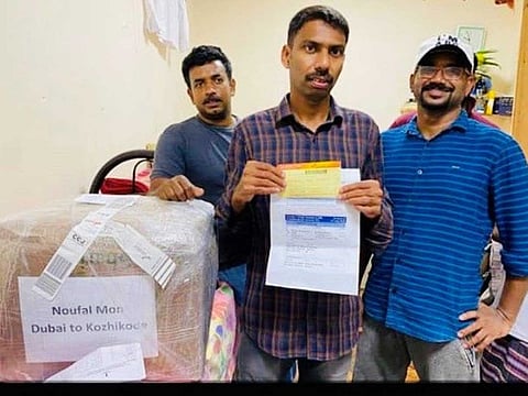Indian expat Noufal Moin (centre) with his friends after he was off-loaded from the ill-fate Air India Express flight due to non-payment of visa fine. 